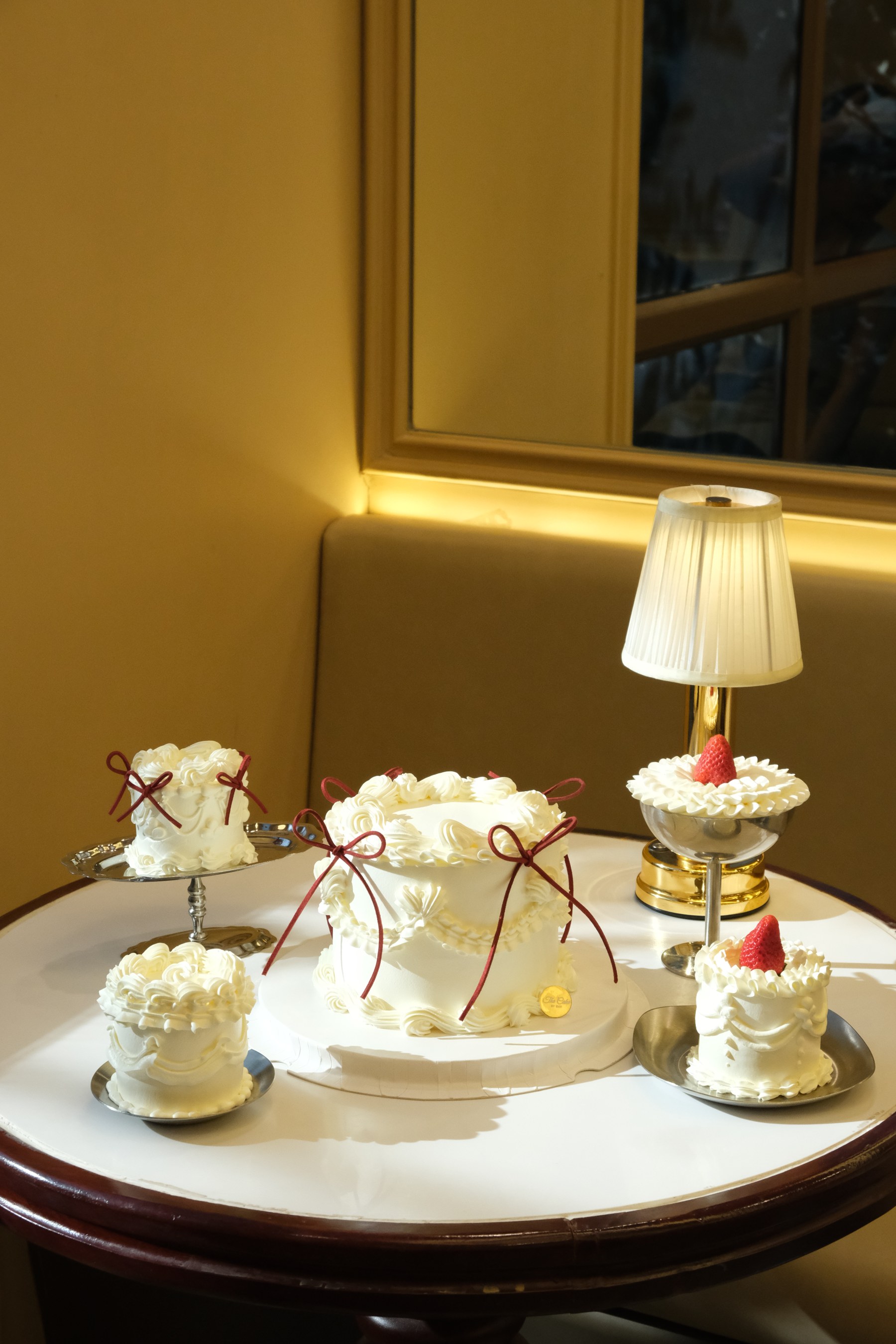 Cream cakes with red bows at The Cake by Dav