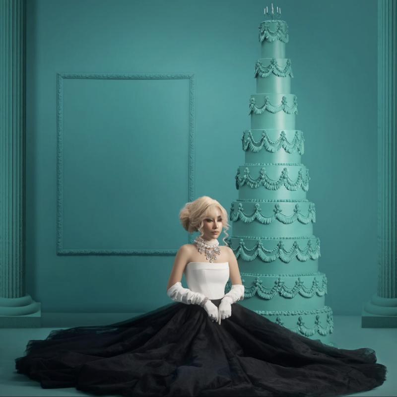 Dav Zalyn beside a tall tiered cake