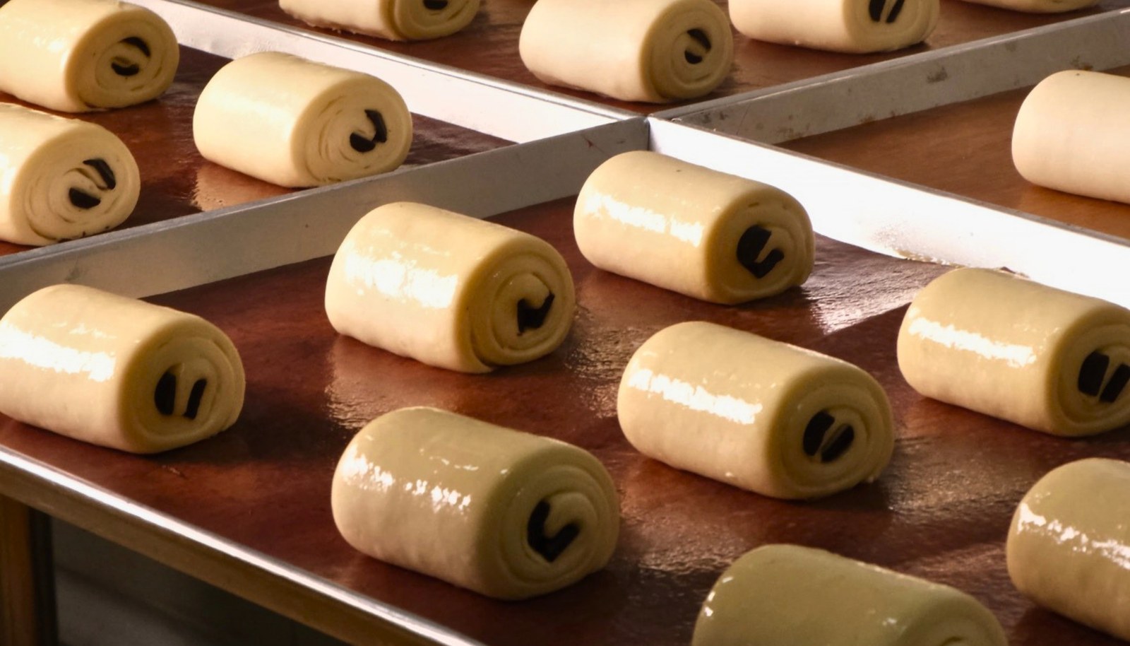 Trays of shaped frozen pain au chocolat dough at Oven Degree