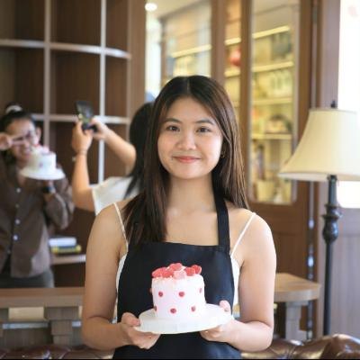 Student holding the cake she decorated